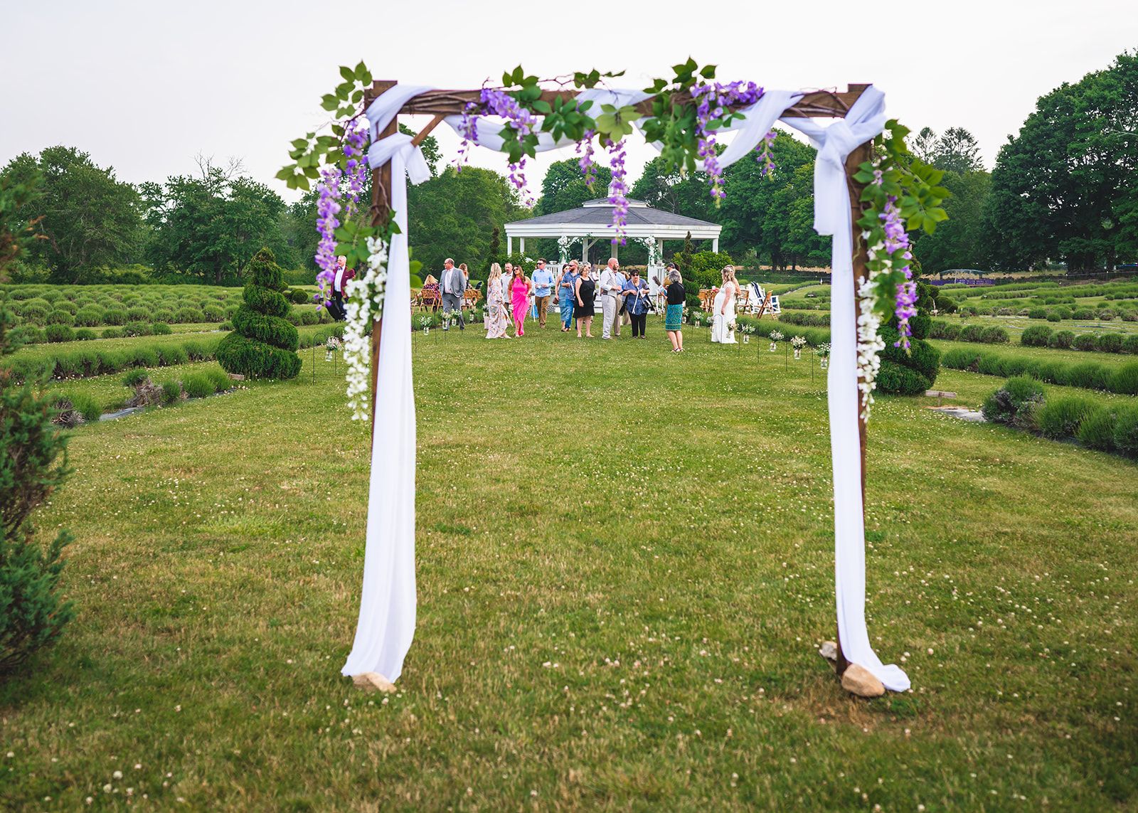 A ceremony arch dressed with flowers in the field