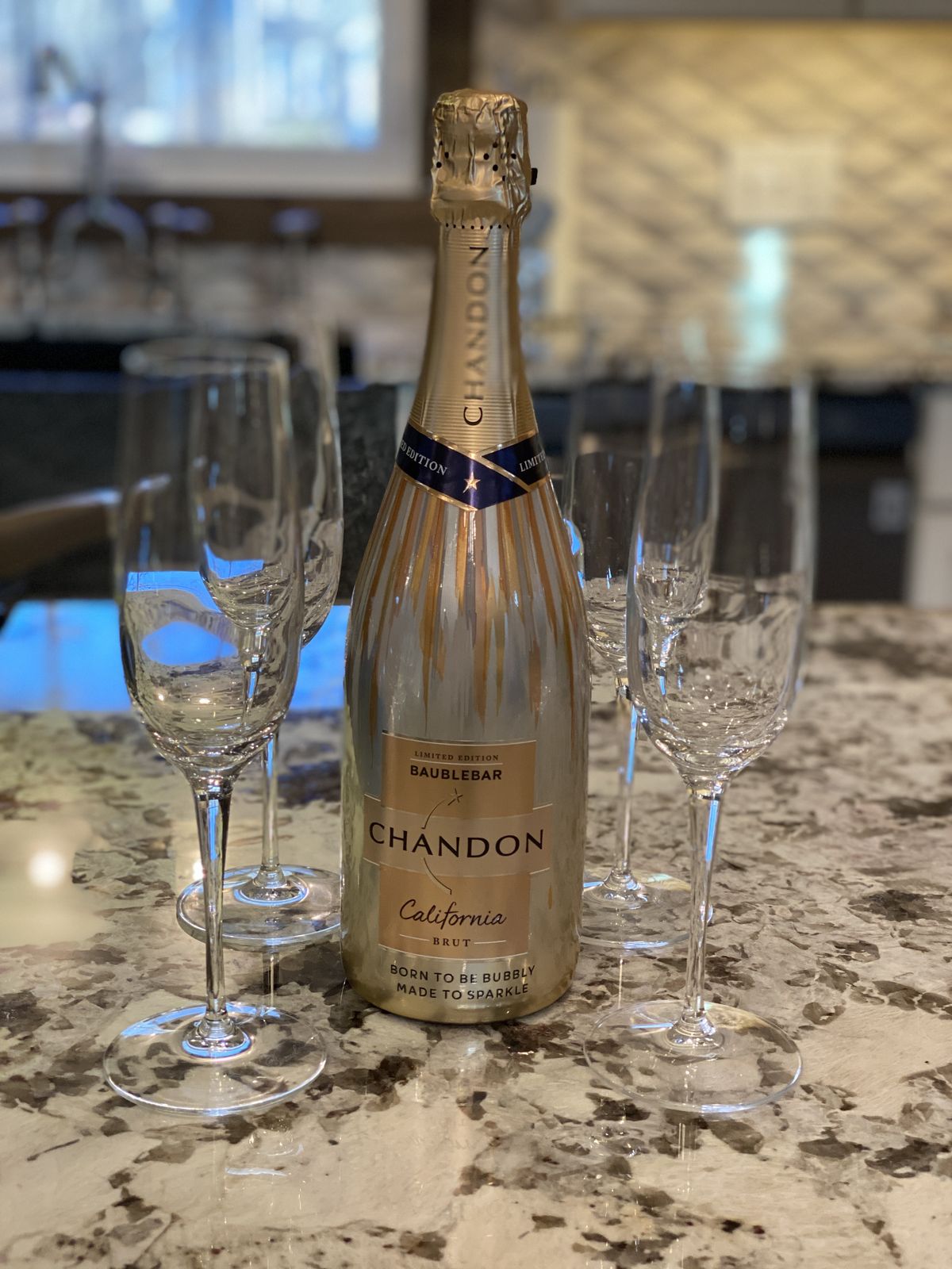 A bottle of sparkling wine with flutes in the suite kitchen