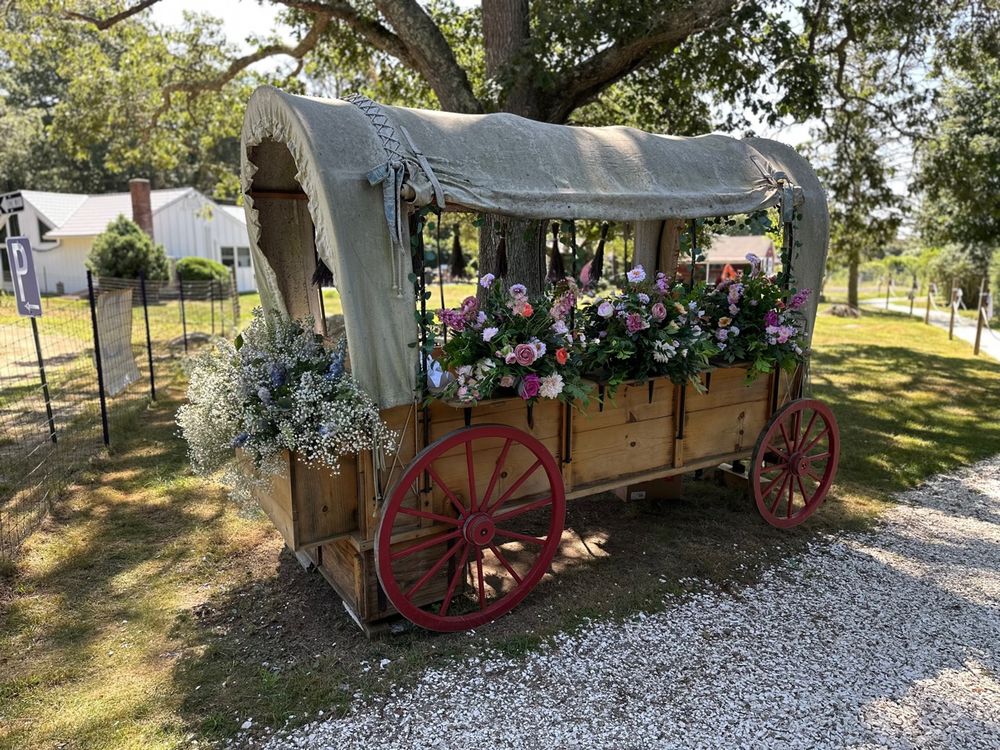 The farm's welcome wagon covered in wedding flowers